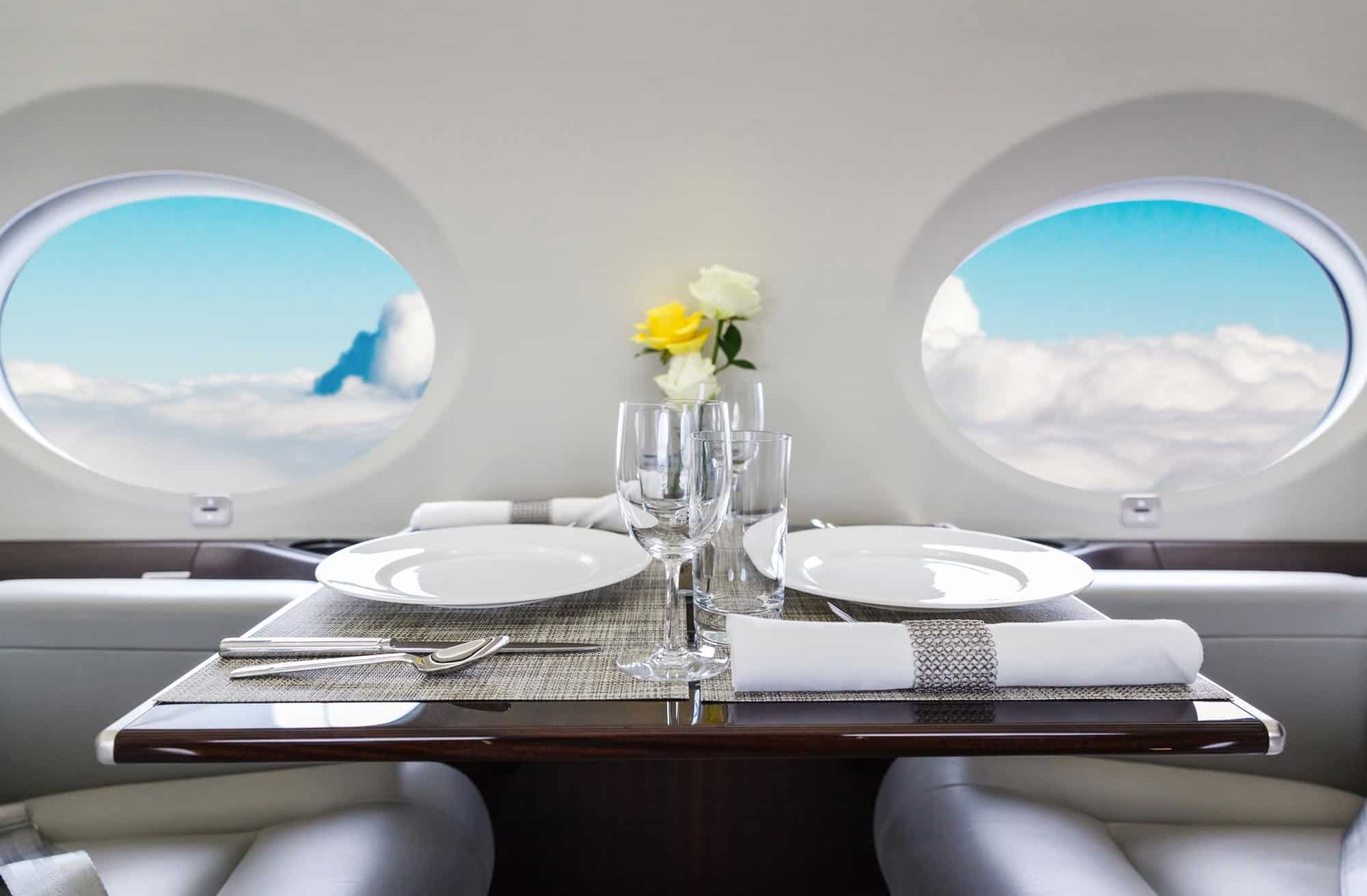 a dinner set up in a private jet with window view