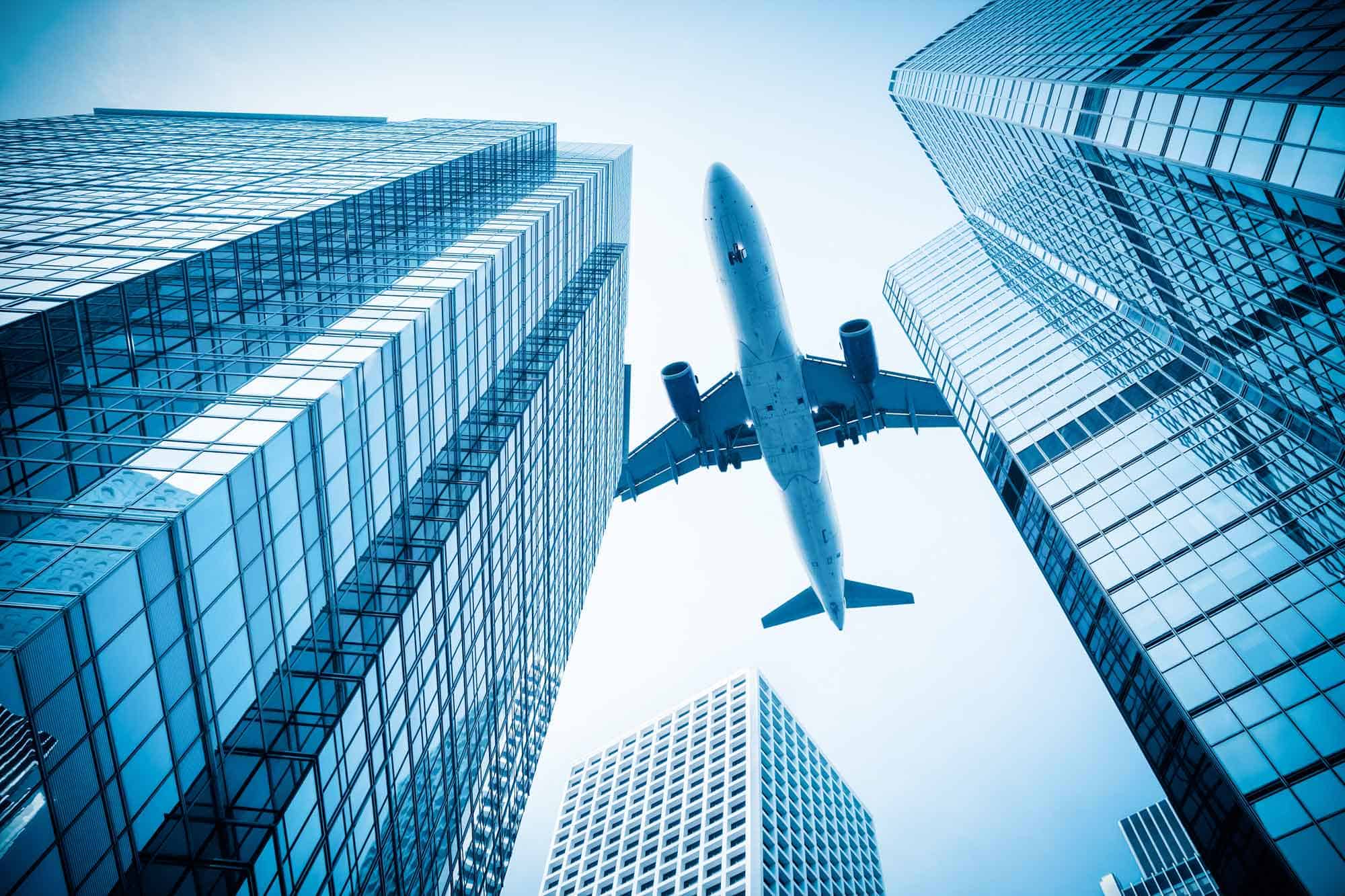 A commercial plane flying over sky scrapers